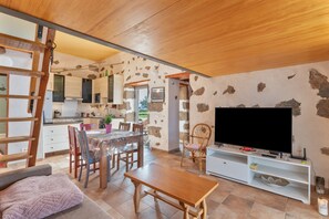 A compact living space with a kitchen, dining area, and a TV. - Holiday Home 'El Tablero' with Sea Views, Private Terrace and Wi-Fi (Tinajo)