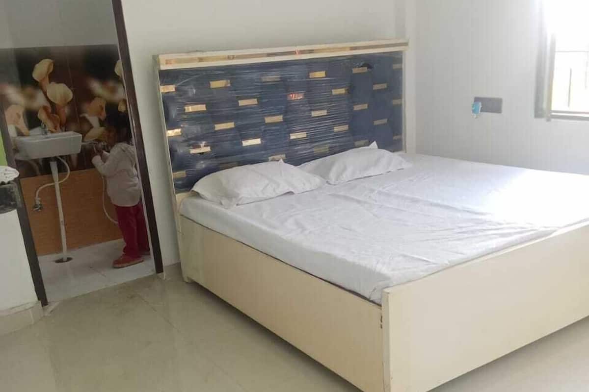 Un dormitorio con cama, espejo y armario.