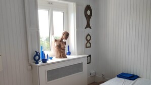 A bedroom with a bed, a radiator, a window, and a wall with decorative fish-shaped mirrors. - A cocoon of calm and serenity in the heart of Saint-Florentin (Saint-Florentin)