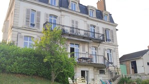 A large, multi-story building with a symmetrical facade, multiple balconies, and a well-maintained lawn in the foreground. - A cocoon of calm and serenity in the heart of Saint-Florentin (Saint-Florentin)