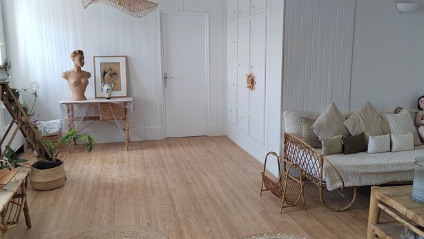 A spacious room with wooden flooring, a sofa set, a wicker chair, and a small table with a vase. - A cocoon of calm and serenity in the heart of Saint-Florentin (Saint-Florentin)