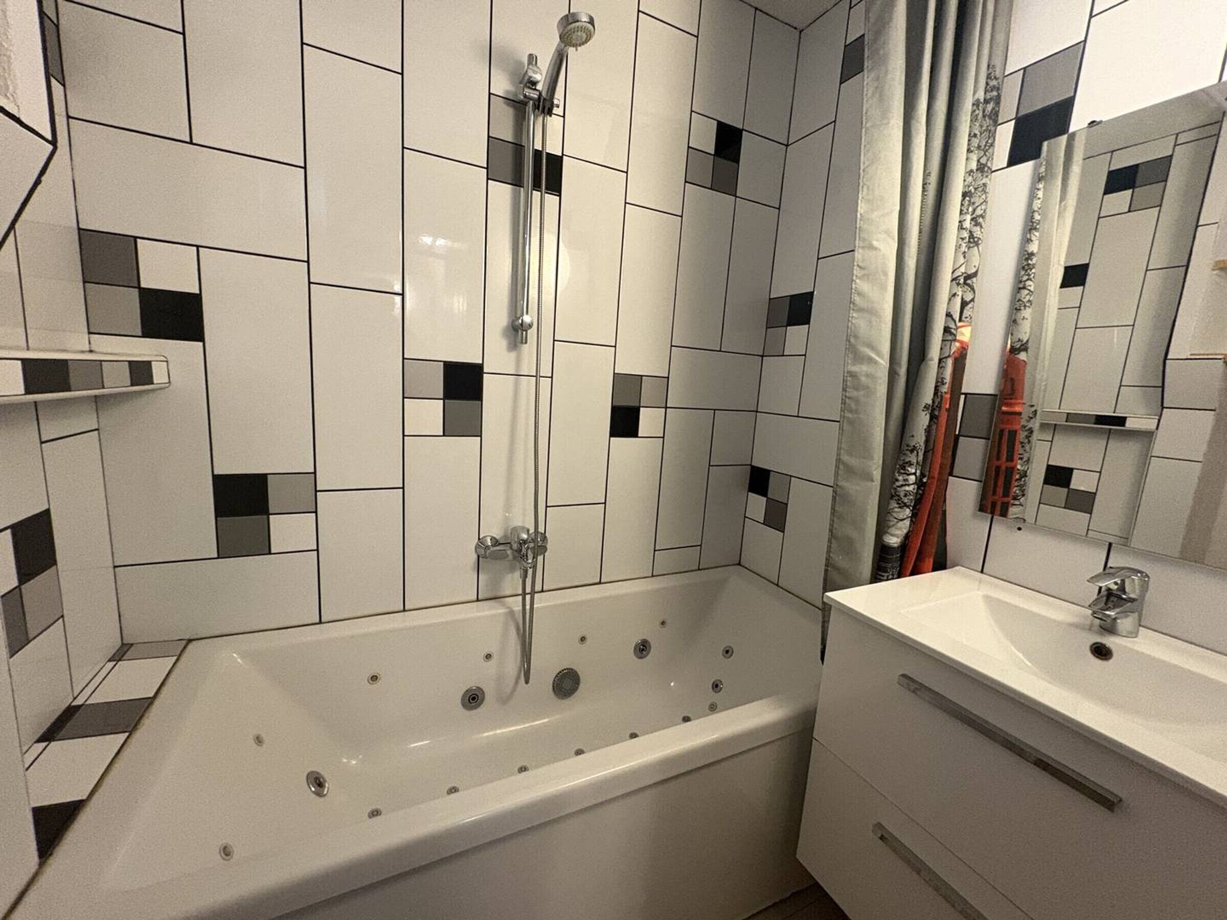 A modern bathroom with a freestanding bathtub, a vanity with a sink, and a shower with a handheld showerhead.