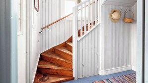 A wooden staircase with white walls and a blue carpet.