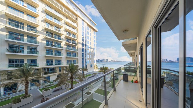 Un edificio moderno con varios balcones que dan a la costa.