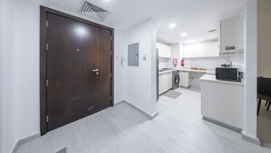 Una cocina moderna con armarios blancos, un microondas y una lavadora.