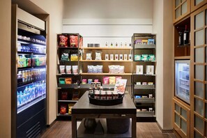 Un bar de aperitivos con bebidas frías, snacks empaquetados y salsas.