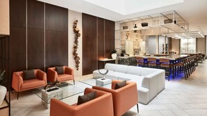 A modern hotel lobby with a bar area, seating arrangements, and a distinctive wall sculpture. - Close to Caesars Superdome + Restaurant. Bar. Gym. (New Orleans)