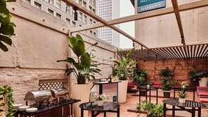 An outdoor patio area with a grill, seating, and potted plants. - Close to Caesars Superdome + Restaurant. Bar. Gym. (New Orleans)