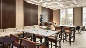A modern dining area with marble tables, leather chairs, and geometric ceiling lighting. - Close to Caesars Superdome + Restaurant. Bar. Gym. (New Orleans)