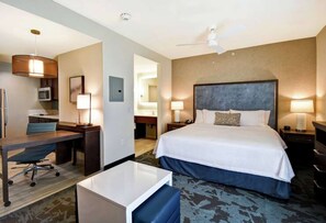 Une chambre d’hôtel avec un lit, un bureau, une chaise et une petite table.