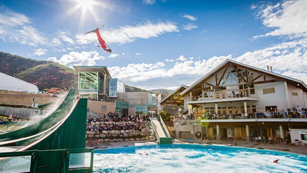 Ein Skigebiet mit Seilbahn, Schwimmbadbereich und Zuschauern.