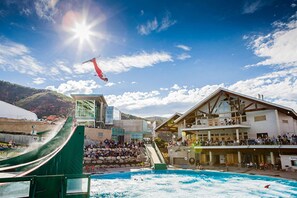 Un centro de esquí con telesilla, zona de piscina y espectadores.