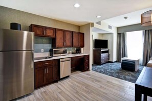 A modern kitchen with stainless steel appliances, wooden cabinets, and a flat-screen TV. - King Suite w/ Kitchen Salt Lake City Airport+Pool (Salt Lake City)