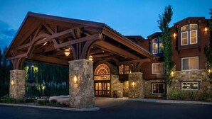 A large, multi-story building with a prominent wooden overhang and stone pillars. - Free Shuttle to Ski Resorts + Restaurant & Hot Tub (Jackson)