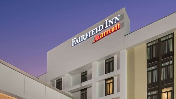 Un hôtel Fairfield Inn Marriott doté d’une façade moderne, de grandes fenêtres et d’un hall d’entrée bien éclairé.