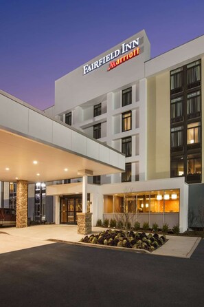 Un hôtel Fairfield Inn Marriott doté d’une façade moderne, de grandes fenêtres et d’un hall d’entrée bien éclairé.