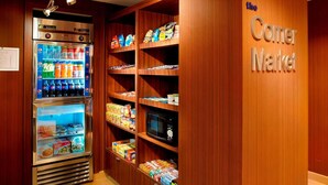 Un distributeur automatique et des étagères remplies d’en-cas et de boissons, installés dans un coin d’un hôtel.