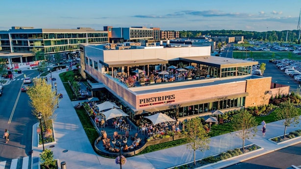 Un restaurant Pinstripes doté d’une terrasse et d’un parking.