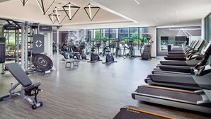 Een moderne sportschool met loopbanden, elliptische trainers en gewichten.