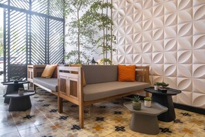 A modern lounge area with a sofa, two side tables, and decorative plants. - w Designer Loft in the Heart of Bocagrande (Cartagena)