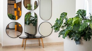 A wall with multiple round mirrors and a potted plant. - w Designer Loft in the Heart of Bocagrande (Cartagena)