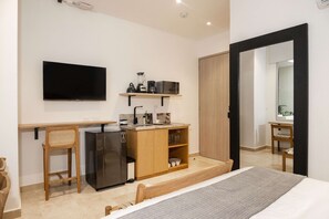 A modern hotel room with a bed, a flat-screen TV, a kitchenette with a refrigerator, a coffee maker, and a microwave. - w Awesome Loft in the Heart of Bocagrande (Cartagena)