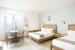 A hotel room with a bed, bedside tables, a desk, and chairs. - w Boutique Loft in the Heart of Bocagrande (Cartagena)