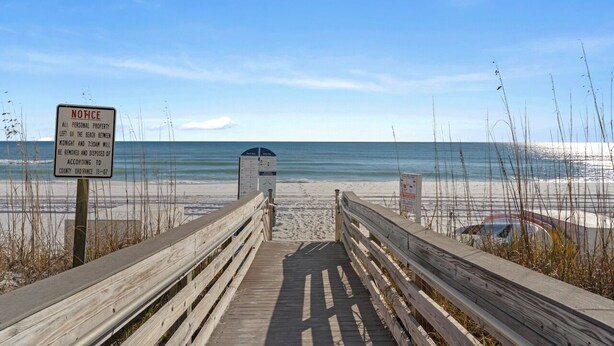 A wooden boardwalk leading to a beach with a notice sign. - Waters Edge 115 ~ Ground Floor ~ Beach Boardwalk Right Outside Your Door! (Fort Walton Beach)