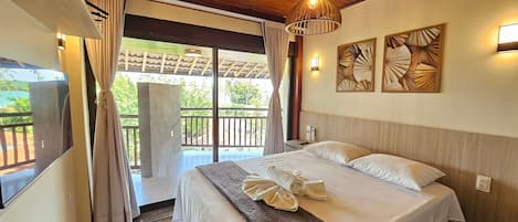A bedroom with a bed, curtains, a TV, and a balcony with a view.