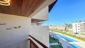 A hotel balcony with a view of a swimming pool and palm trees. - Atlantico Praia dos Carneiros - Proximo da Igrejinha (Tamandaré)