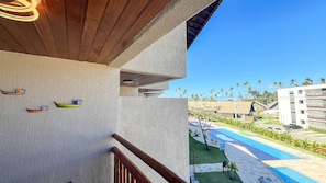A hotel balcony with a view of a swimming pool and palm trees. - Atlantico Praia dos Carneiros - Proximo da Igrejinha (Tamandaré)