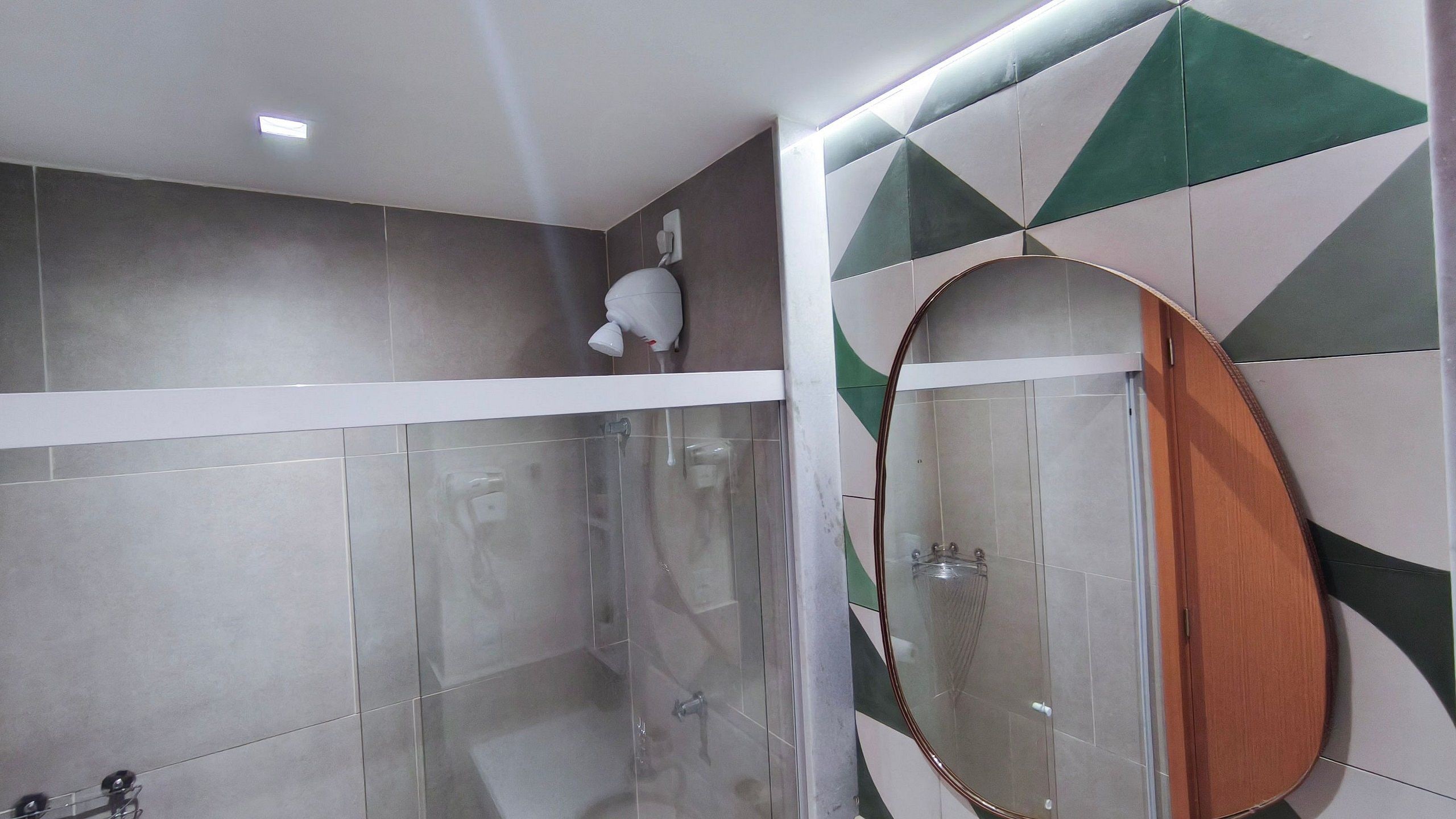 A shower with a glass door, a towel rack, and a mirror.
