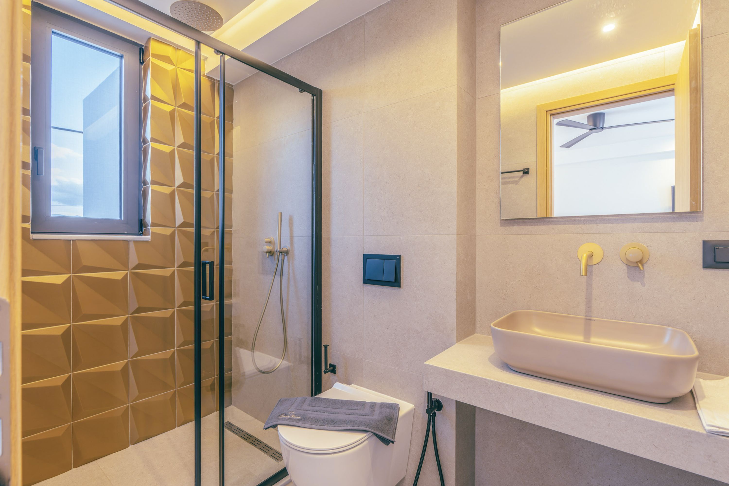 Une salle de bain moderne avec une douche à parois de verre, des toilettes et un lavabo avec un miroir au-dessus.