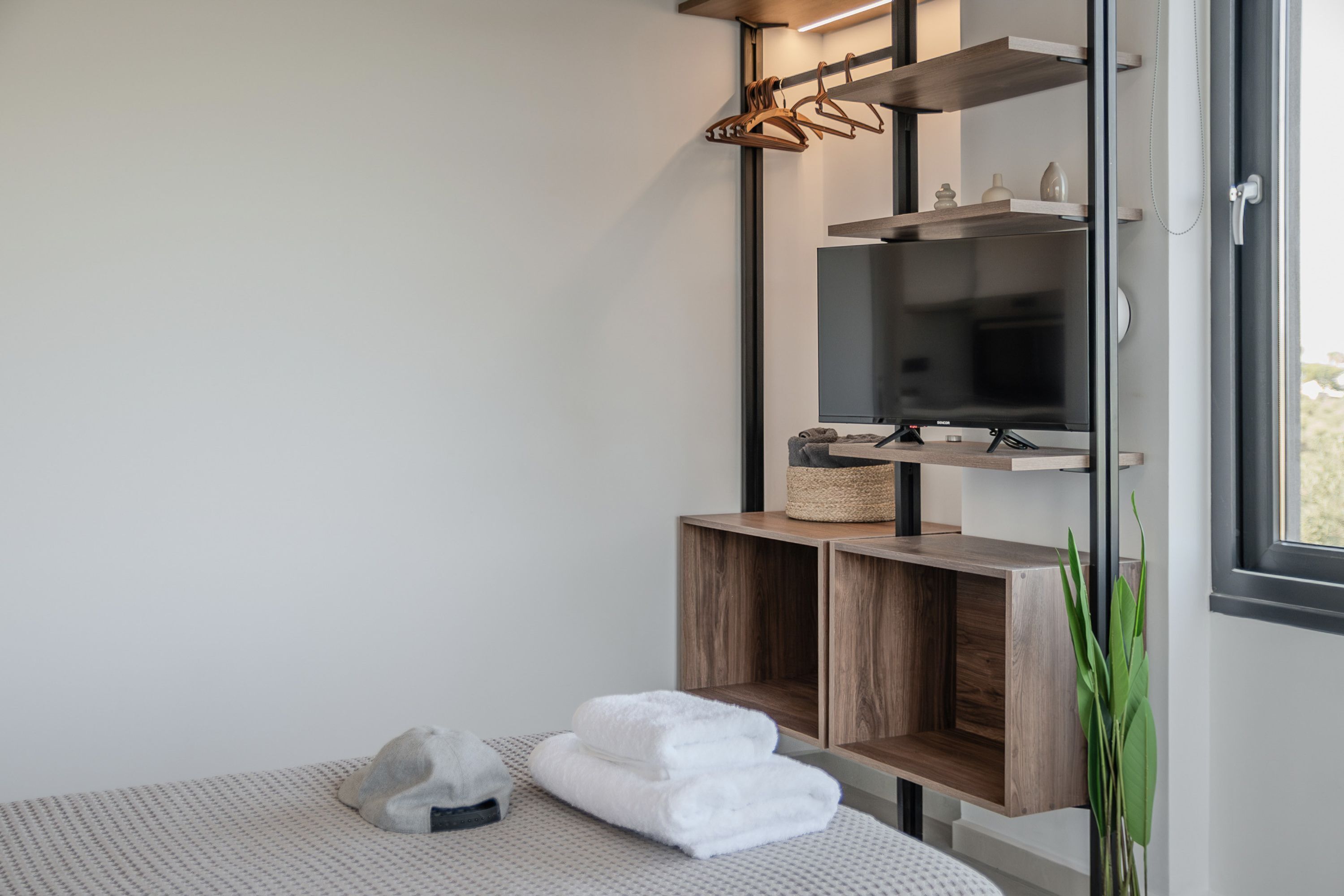 Une salle de bain moderne avec un meuble-lavabo en bois, un porte-serviettes et un téléviseur.