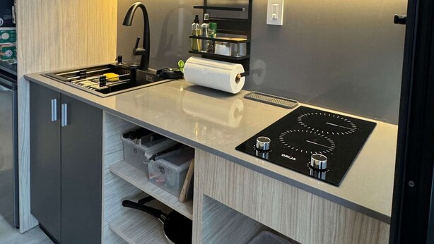 A compact kitchen with a modern design, featuring a built-in stove, a sink, and a shelf with kitchenware. - w Forest Escape Bungalow With Nature View (Caimitillo)