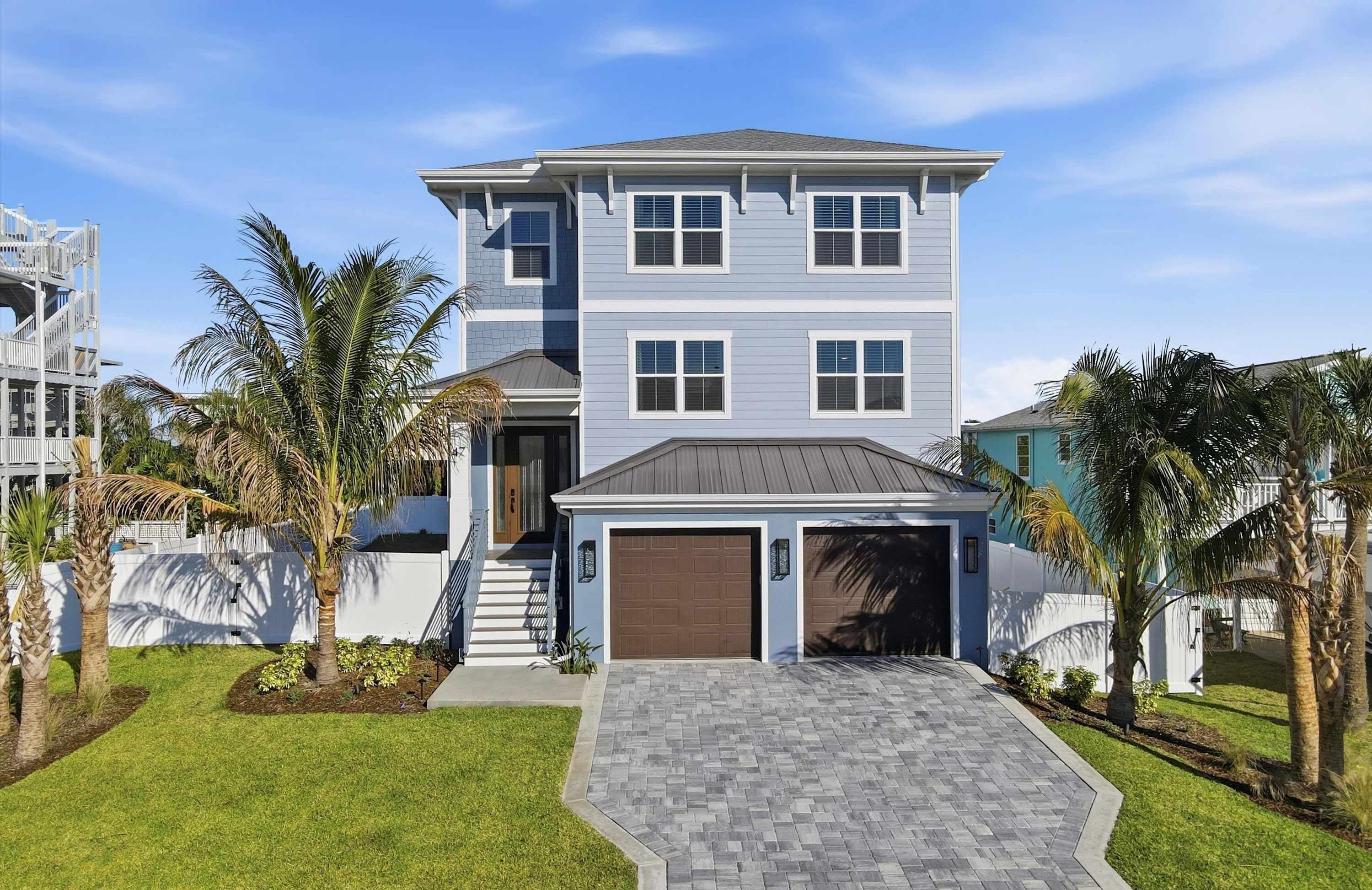 A two-story house with a garage, a front porch, and a driveway.