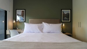 A neatly made bed with white linens, two bedside lamps, and two framed pictures on the wall. - w Graceful 1BR w/ Perfect Balcony in Miraflores (Lima)