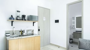 A compact kitchen with a countertop, wooden cabinets, and a microwave. - w Upscale Loft in the Heart of Bocagrande (Cartagena)