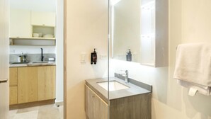 A modern bathroom with a large mirror, a sink, and a towel hanging on the wall. - w Inviting Loft in the Heart of Bocagrande (Cartagena)