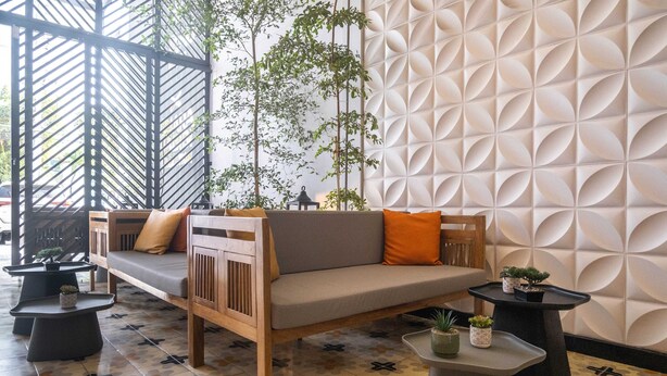 A modern lounge area with a sofa, two side tables, and decorative plants. - w Trendy 2BR in the Heart of Bocagrande (Cartagena)