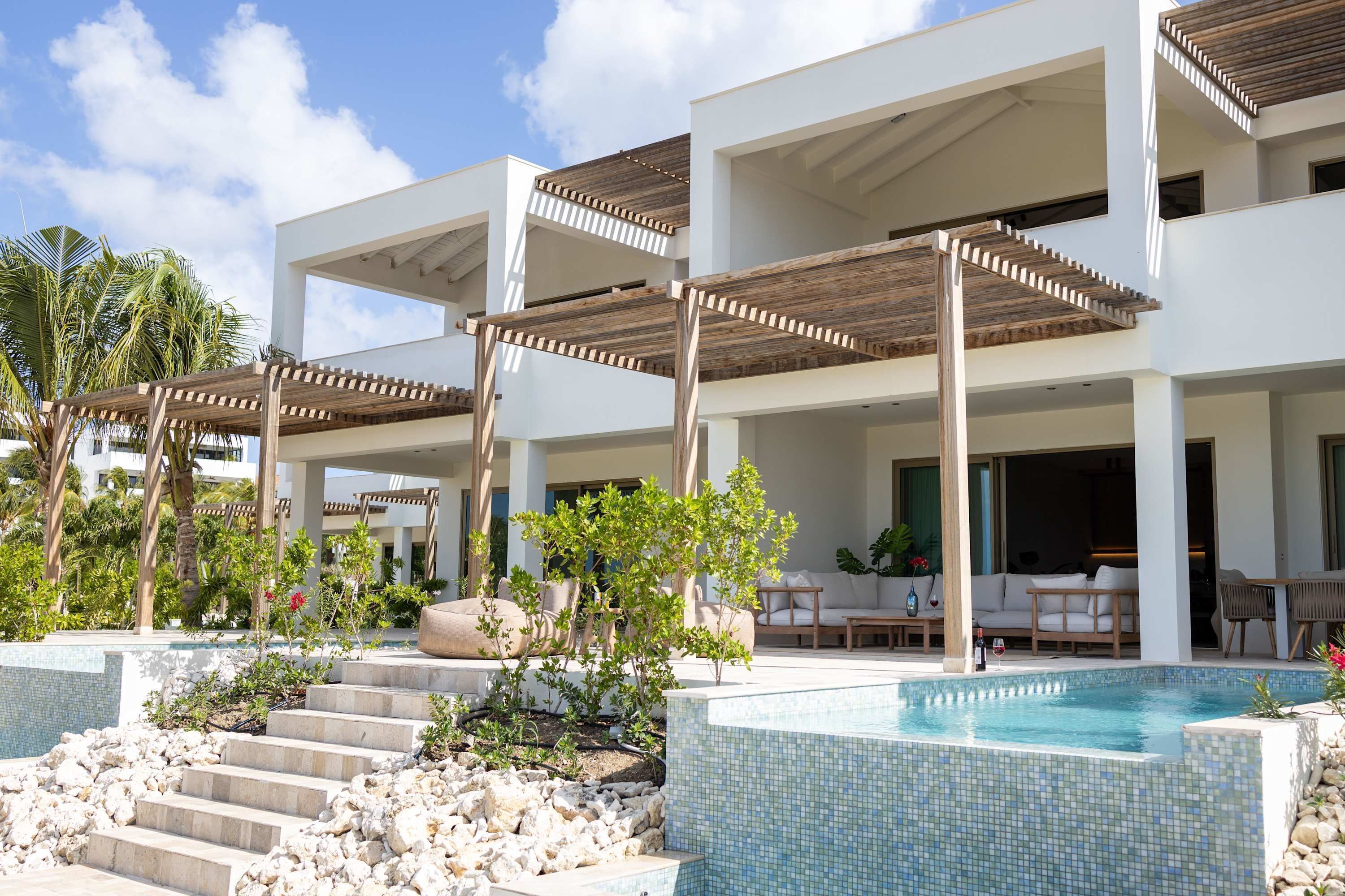 A modern resort with a swimming pool, outdoor seating, and a multi-level structure.