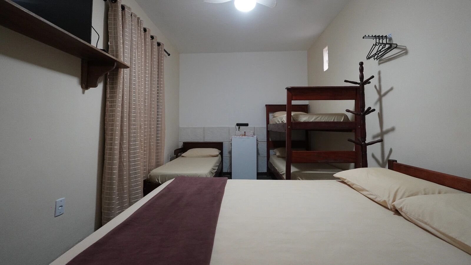 A room with bunk beds, a desk, and a chair.