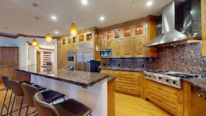 A modern kitchen with granite countertops, wooden cabinets, stainless steel appliances, and pendant lighting. - Westridge Condo 19 -Updated Condo Walk to River Run Lifts and Downtown (Ketchum)