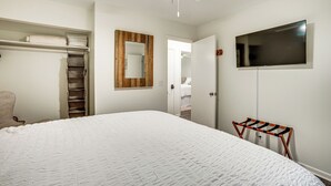 A bedroom with a large bed, a wardrobe, a mirror, and a TV mounted on the wall. - Relax Fireside: Family Home 6 Mi to Dtwn Beaufort! (Beaufort)