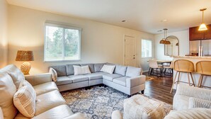 A spacious living room with a sectional sofa, a dining area, and a kitchen with bar stools. - Relax Fireside: Family Home 6 Mi to Dtwn Beaufort! (Beaufort)