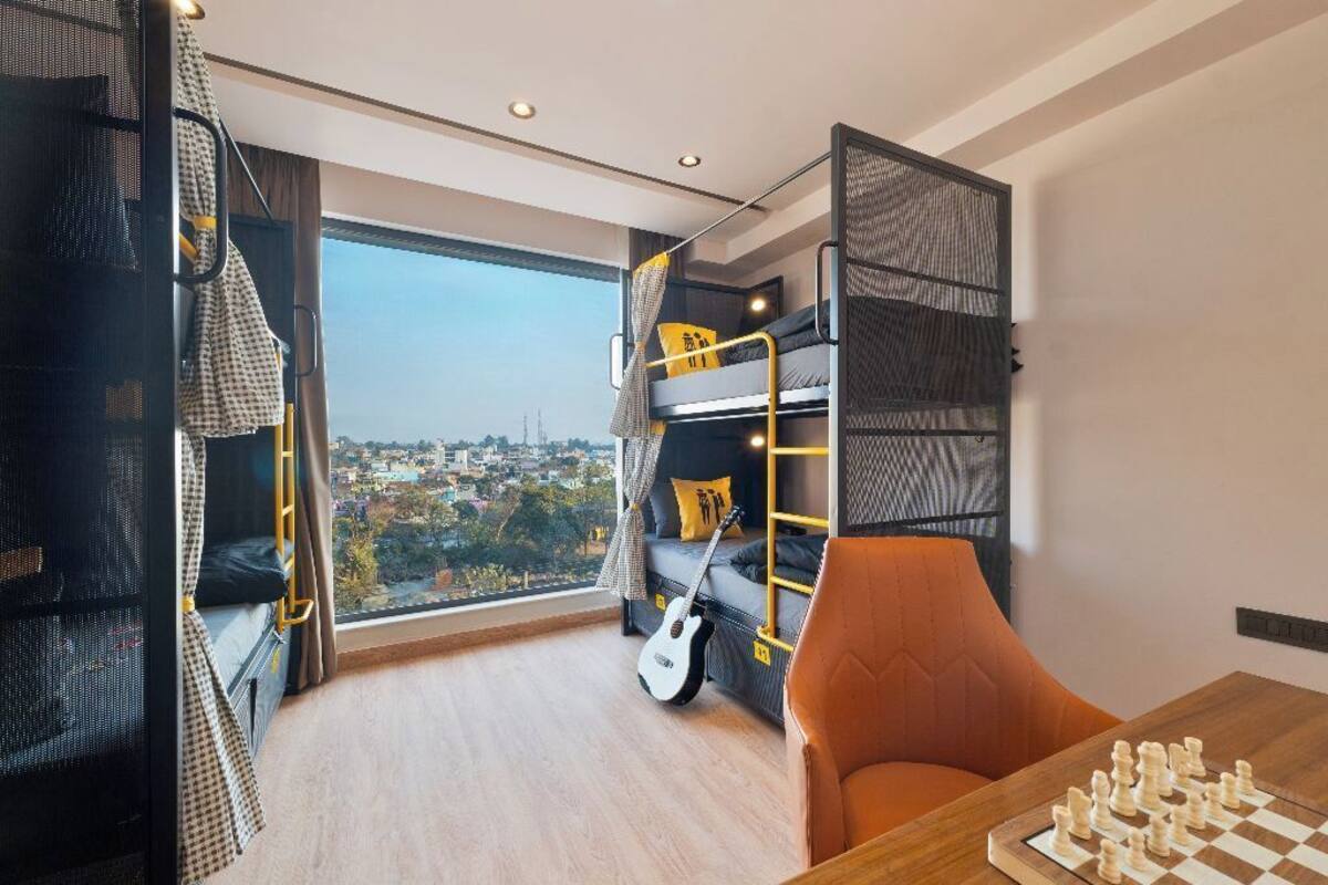 A room with bunk beds, a guitar, and a chessboard.
