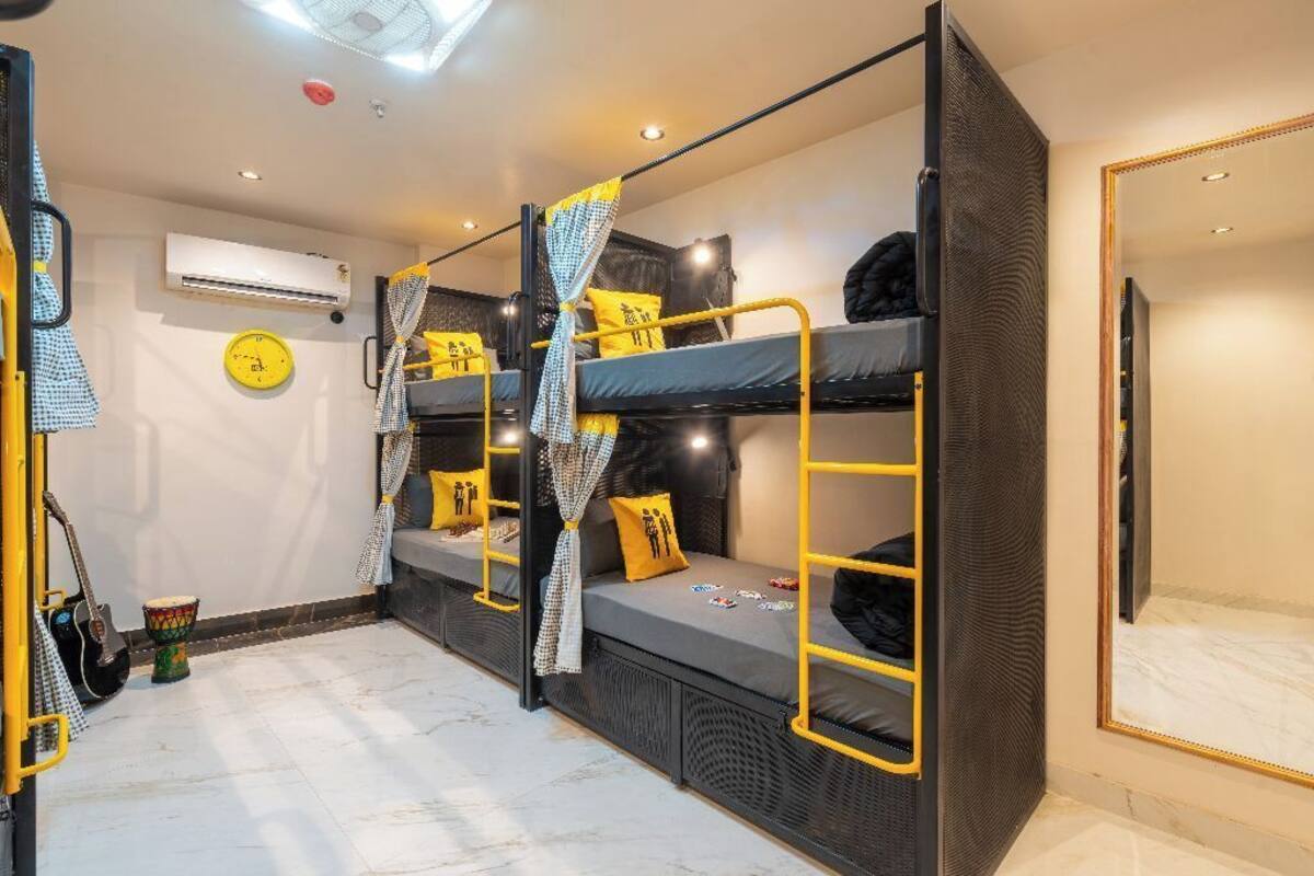 A bunk bed room with a mirror, a clock, and a small drum.