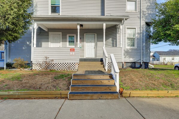 A two-story building with a front porch, a set of wooden steps leading to the entrance, and a 'Private Property' sign.