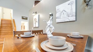 A dining table set with white plates, bowls, and cutlery, with a white ceramic sculpture in the center. - Willamette Valley Home on Working Horse Farm! (Scio)