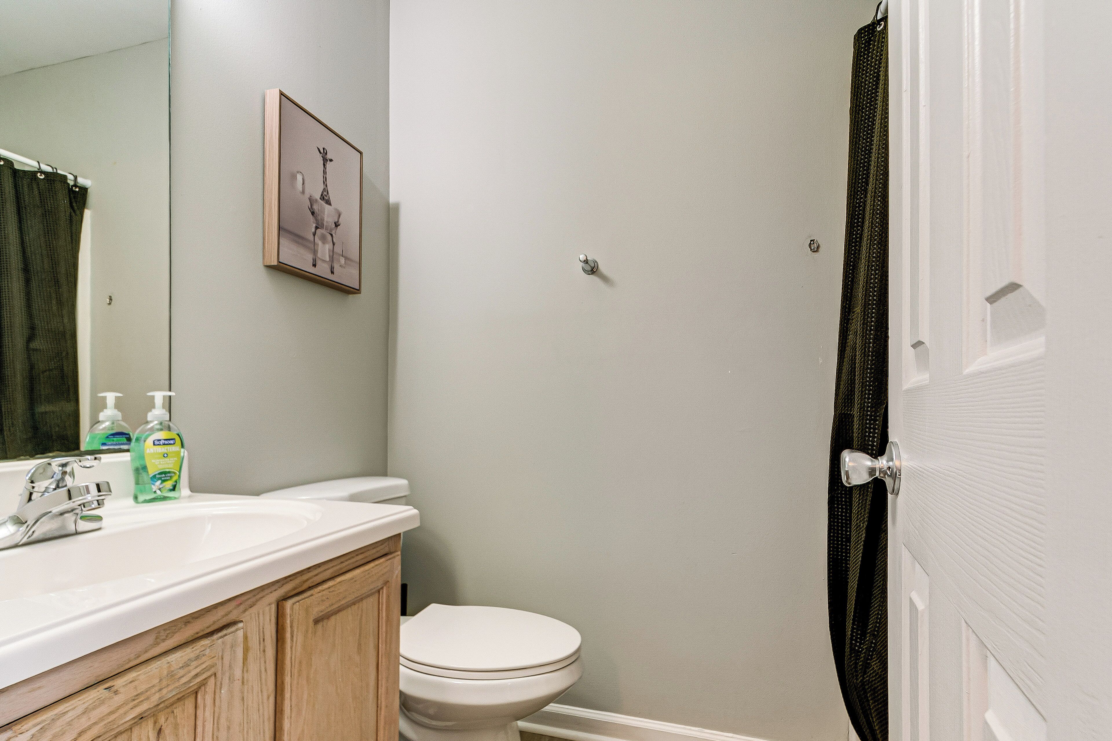 A bathroom with a white sink, a toilet, and a shower curtain.